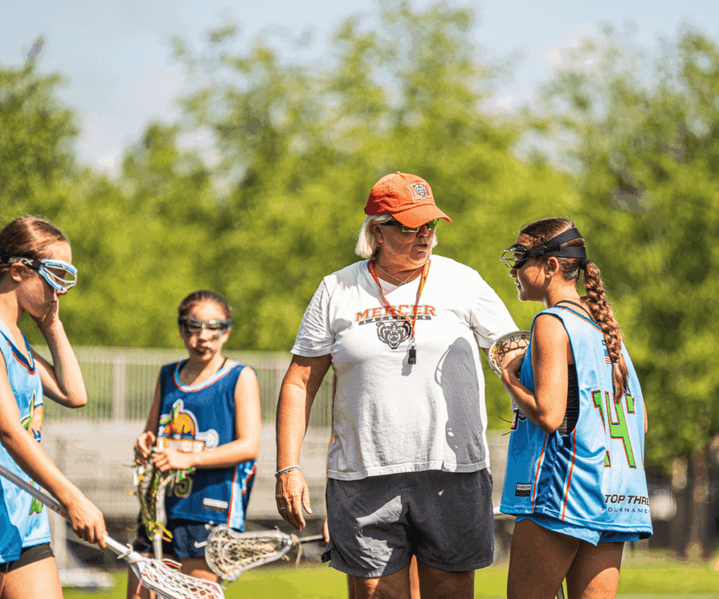 Lacrosse coach speaking with a young player during a game timeout